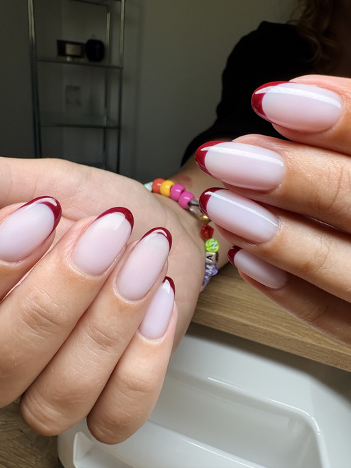 Ongles amande longs, rose laiteux avec une French bordeaux fine et brillante.