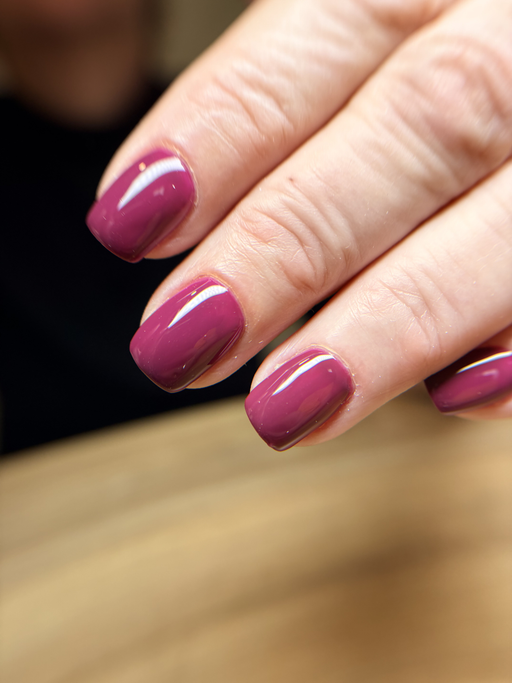 Ongles carrés courts, framboise profond uni à la finition très brillante.